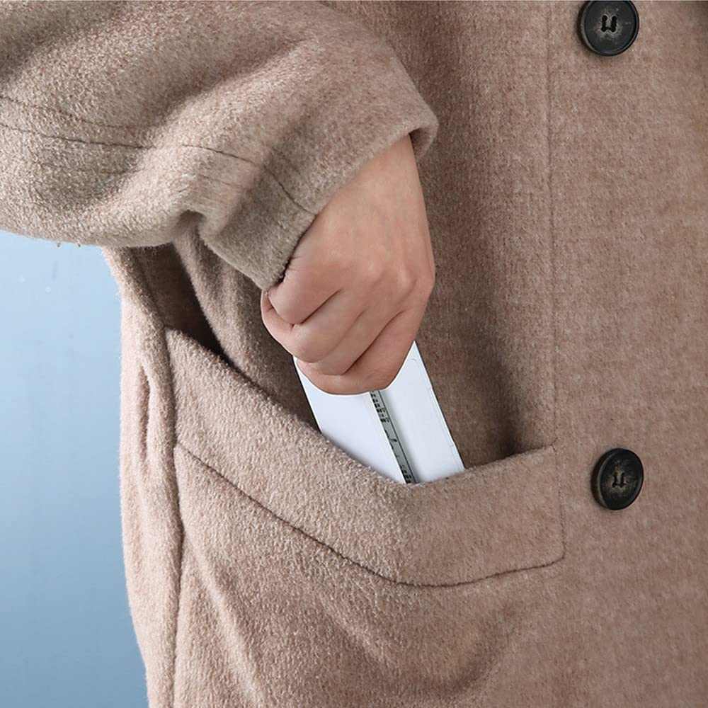 Mini Heat Sealer in white with a slim rectangular body, partly tucked into the pocket of a beige coat