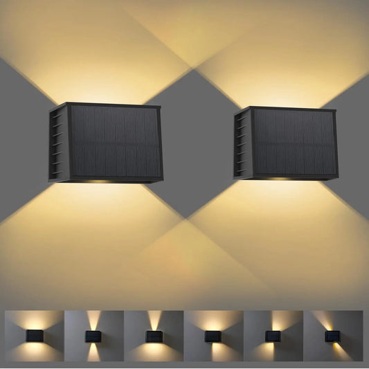 Two solar wall lights emitting a warm glow on a gray background.